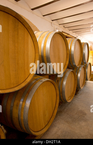 wine wooden oak barrels stacked in a row at Mediterranean winery Stock Photo