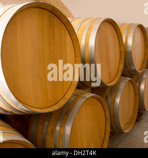 wine wooden oak barrels stacked in a row at Mediterranean winery Stock Photo