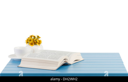 A coffee cup and opened book on the blue wooden table Stock Photo
