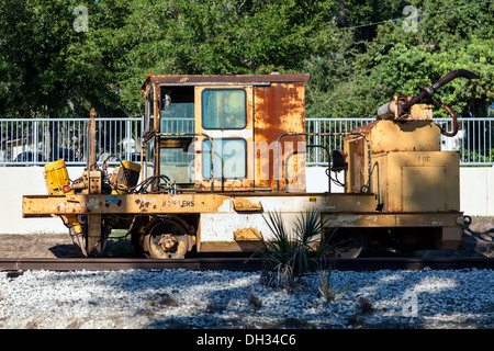 Old rusting track-mounted railroad utility repair vehicle sitting on a side track spur line in Mount Dora in Florida. Stock Photo