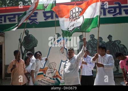 Congress political supporters waving Congress party flags celebrating victory with poster of Indian Indian Prime Minister Dr Manmohan Singh Mumbai Maharashtra India Asia Stock Photo