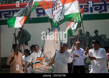 Congress political party supporters celebrating victory waving Congress flags with poster of Indian Prime Minister Dr Manmohan Singh Mumbai Maharashtra India Asia Stock Photo