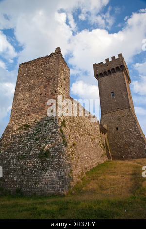 Imposing medieval stone ramparts and a tall square tower rise beside ...
