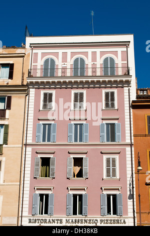 House painted in pink with blue window shutters on Via Cavour, Rome, Italy Stock Photo