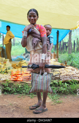 Baiga mother carrying child on her back. Baiga Tribe, Chada village, Madhya Pradesh, India Stock Photo