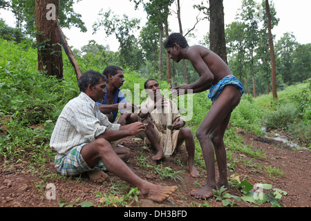 Baiga men enjoying Mahua Liquor. Baiga Tribe, Chada village, Madhya Pradesh, India Stock Photo