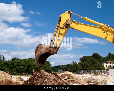 yellow excavator working on building site Stock Photo