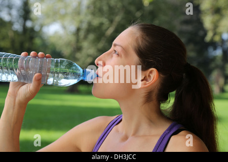 Young woman drinking water from a bottle after sports or running Stock Photo