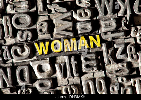 Old lead letters forming the word WOMAN Stock Photo