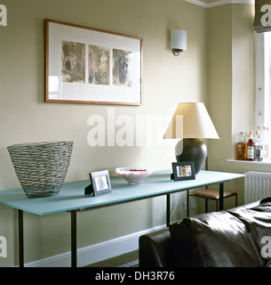 Glass vase and metal lamp on glass side table in modern townhouse living room Stock Photo