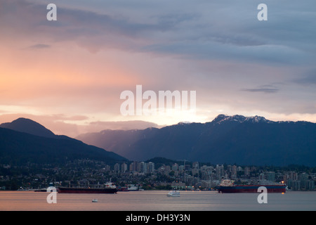 Striking sunset over Vancouver Harbour, North Vancouver, and Grouse Mountain as seen from downtown Vancouver, BC, Canada. Stock Photo
