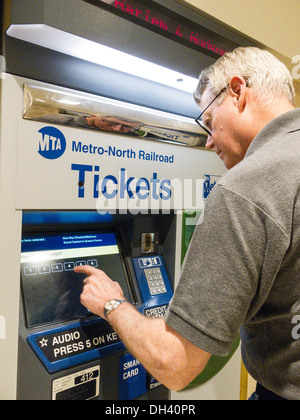 Man Purchasing Metro North Transit Train Tickets at Self Serve Vending Machine, Grand Central Terminal, NYC Stock Photo