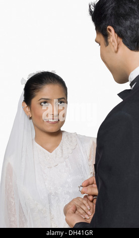 Close-up of a bridegroom placing a ring on his bride's finger Stock Photo