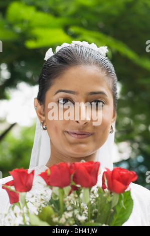 Portrait of a newlywed bride holding a bouquet of flowers and smiling Stock Photo