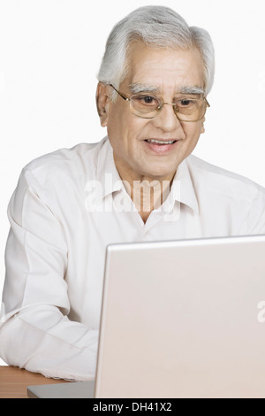 Senior man using a laptop and smiling Stock Photo