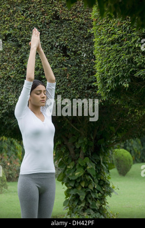 Woman practicing yoga in a park Stock Photo