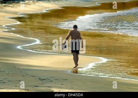 man walking on Kovalam beach kerala India Stock Photo
