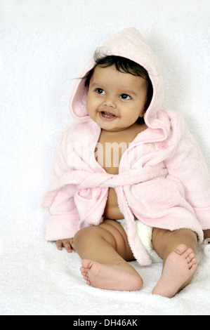 Indian baby girl child wrapped pink towel gown diaper nappy sitting on white background   MR#736PA - rmm 184912 Stock Photo