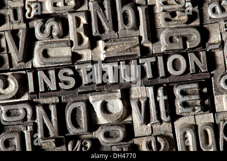 Old lead letters forming the word 'INSTITUTION' Stock Photo