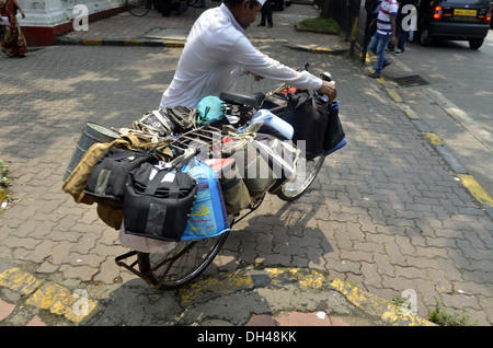 Dabbawala carrying lunchboxes on bicycle Mumbai Maharashtra India Stock Photo