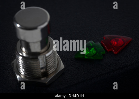 Black case with a push-button and two arrow-shaped indicator lights.   Boîtier noir avec bouton poussoir et voyants lumineux. Stock Photo