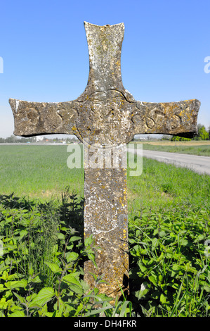Stone cross on the road Stock Photo