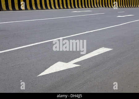 Arrow traffic sign on the road and road divider Mumbai Maharashtra India Asia July 2012 Stock Photo