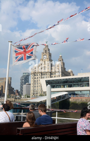 The Royal Liver building seen through flags from a Mersey ferry arriving at the Pier Head. Stock Photo