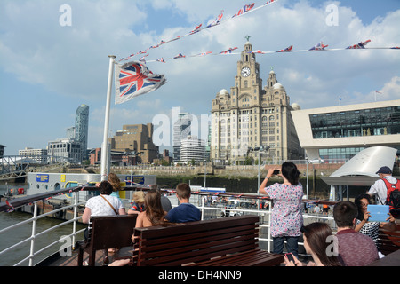 The Royal Liver building seen through flags from a Mersey ferry arriving at the Pier Head. Stock Photo