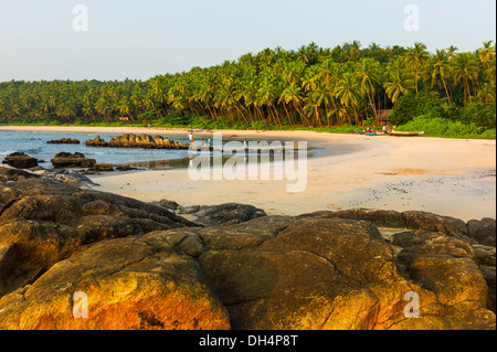 Local residents enjoy a beautiful sunset and low tide along Cherai beach near Thottada village, 10 km south of Kannur, Kerala. Stock Photo