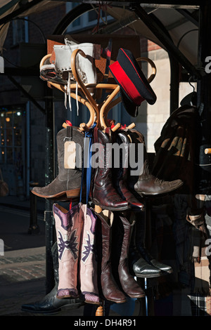 Close up pair of leather boots footwear hanging on rack on outdoor market stall York North Yorkshire England UK United Kingdom GB Great Britain Stock Photo