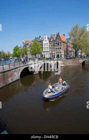 Netherlands, Amsterdam, Crossing of canals called Keizersgracht and Leidsegracht. UNESCO World heritage Site. Small boat