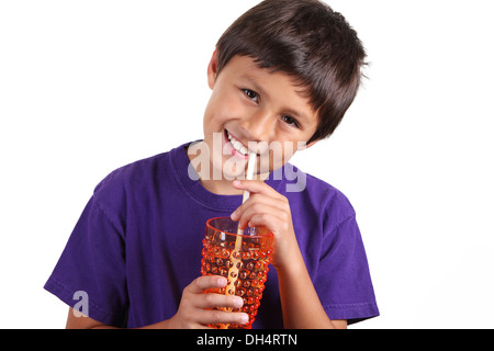 Young boy drinking from orange glass on white background Stock Photo