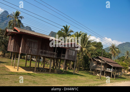 Horizontal view of traditional stilted wooden houses along a countryside street in Laos. Stock Photo