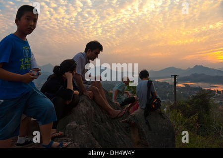 Horizontal view of tourists enjoying the sunset across the Mekong river in Luang Prabang. Stock Photo