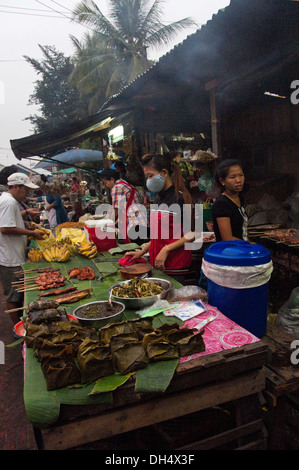 Vertical portrait of ladies serving at a roadside food stall in Luang Prabang. Stock Photo