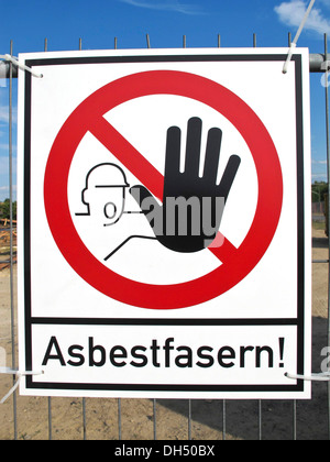 Sign on a fence warning of asbestos fibers Stock Photo
