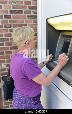 Woman using an ATM Stock Photo