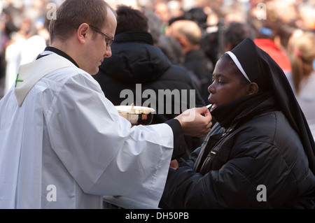 Priest give communion to faithful Stock Photo