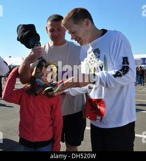 Staff Sgt. Daniel Burgess and his daughter explain his custom running prosthetic to Lt. Gen. Jeffrey Talley, Chief of Army Reserve, after completing the Army Ten Miler today in Washington, DC. Burgess, an Army Reserve Soldier from Garfield Heights, OH, lo Stock Photo