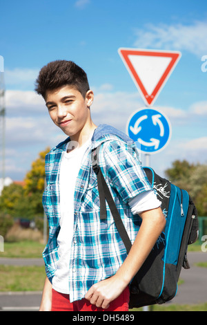 Boy carrying a school bag on the way to school Stock Photo