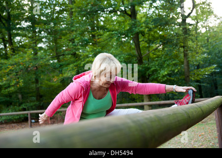 Woman stretching on an outdoor fitness trail Stock Photo