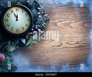 New Year clock over snow wooden background. Five to twelve. Stock Photo