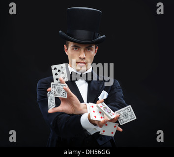 magician showing trick with playing cards Stock Photo