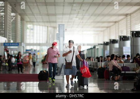 Travelers walk to their gates at Ninoy Aquino International Airport's Terminal 2 in Manila, Philippines. Stock Photo