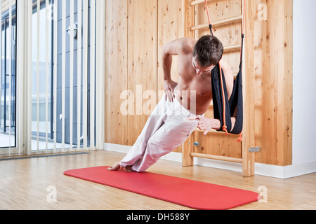 Man doing sling training exercises for strengthening the side muscles Stock Photo