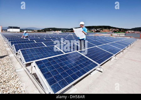 Two technicians inspecting a solar energy plant, Wollsdorf, Weiz District, Styria, Austria Stock Photo