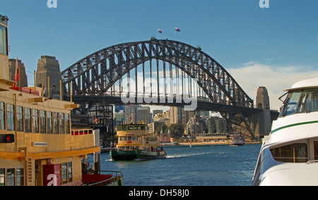 Sydney harbour bridge over blue waters of Darling Harbour with commuter ferry passing by and viewed from among other ferries Stock Photo