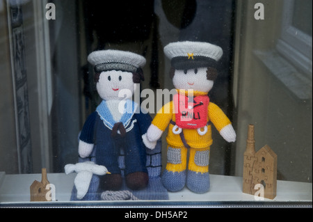 RNLI knitted doll figure next to a sailor in a window in St. Ives Cornwall UK England Stock Photo
