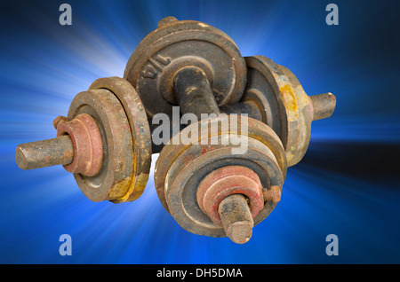 old black dumbells on blue beem light Stock Photo